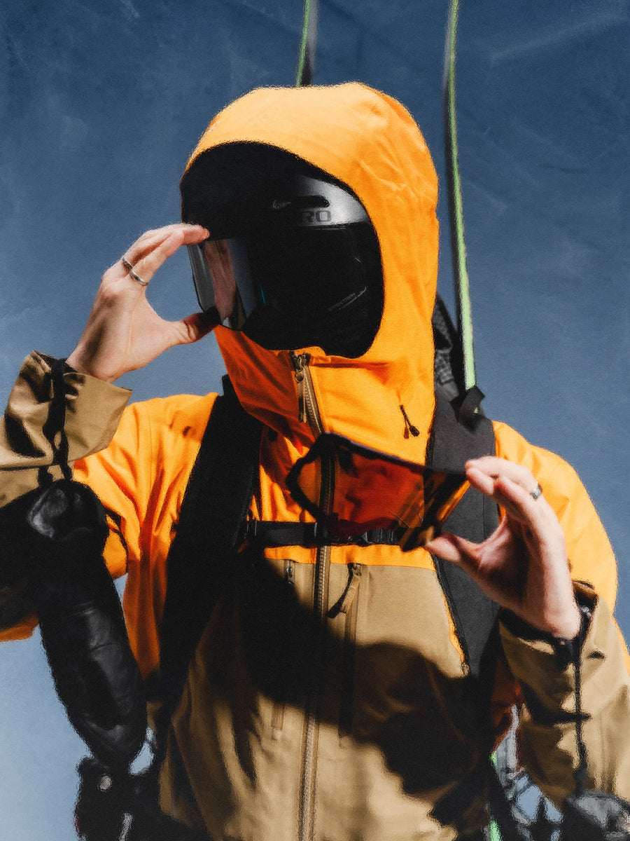 Skieur casqué qui change de lentille, une deuxième lentille dans l'autre main